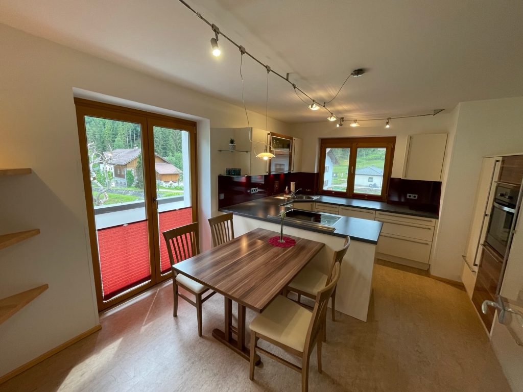 Voll ausgestattete Küche mit Essplatz und Balkon im Appartement der Pension Taurer